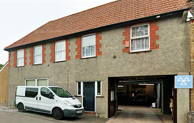 The top entrance of Baytree Road Garage. Blue MOT triangle beside the archway entrance.